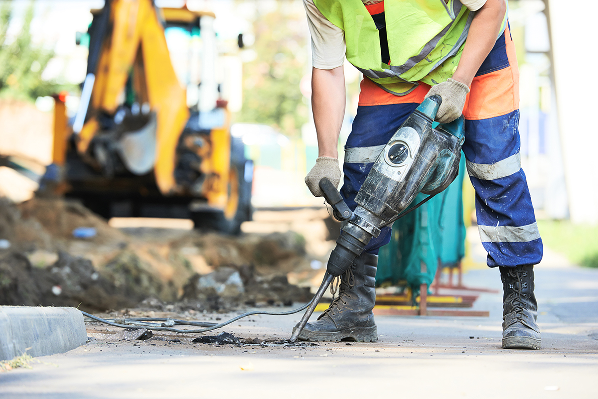 Road crewmember operating a jackhammer.