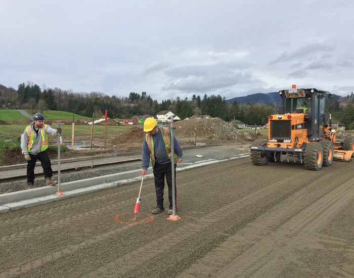 Construction crew members prepping base materials.